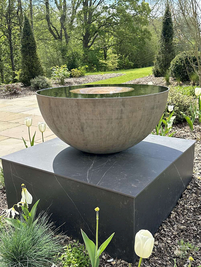 Garden bronze water feature on stone plinth
